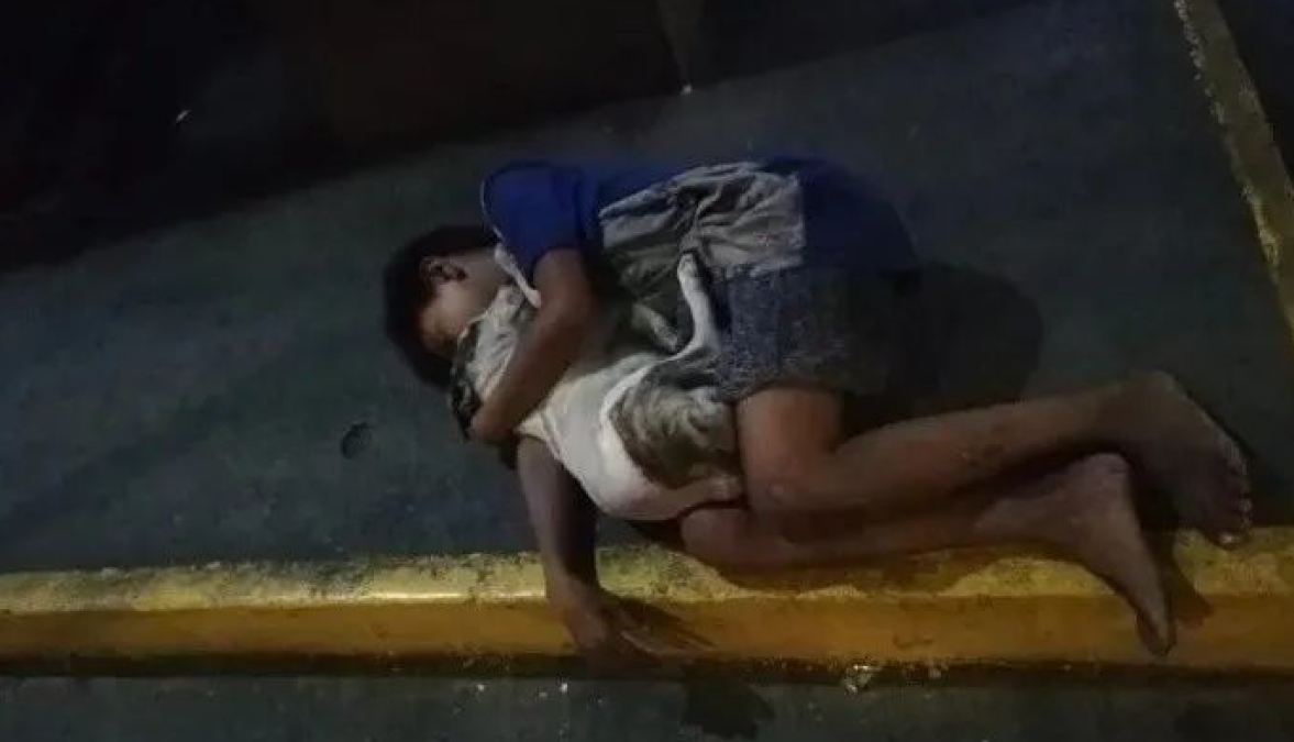 Niño de calle abraza fuertemente a su perro para evitar frío