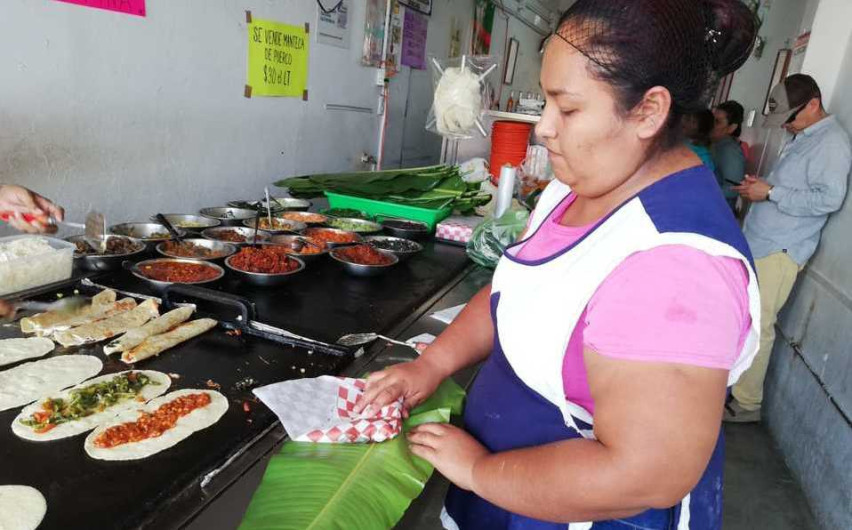 Envuelven alimentos con hojas de tamal en comercio 